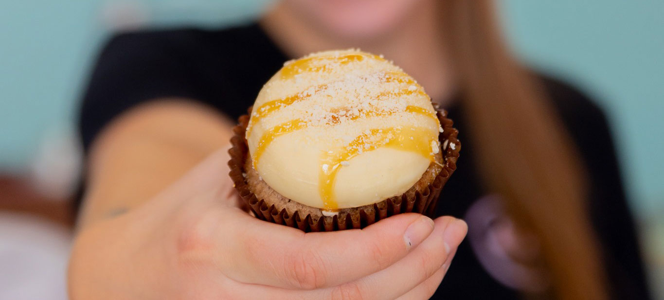 Woman-Holding-Cupcake—Smallcakes Female holding a cupcake in front